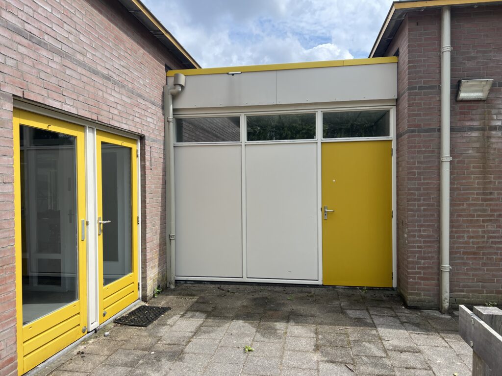 Resultaat na reiniging kunststofplaten buitenruimte van een schoolgebouw door middel van softwash methode door Aquarel
